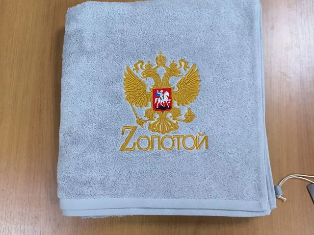 Герб и надпись, вышитые на голубом полотенце